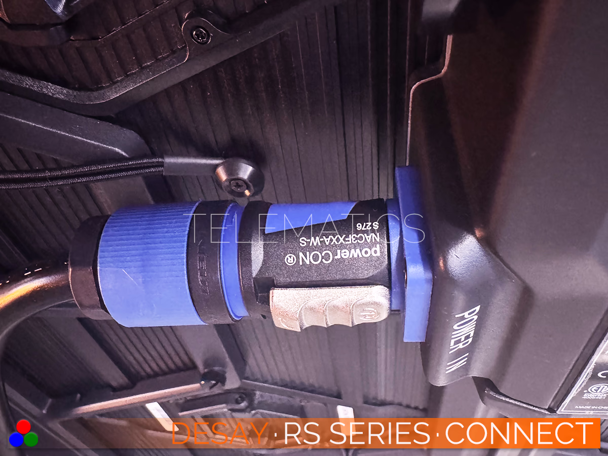 The Art Of LED · Desay RS Series · Telematics Canada Secure connection detail showing a blue Neutrik powerCON plug engaged with the Desay RS Series power inlet, ensuring stable electrical delivery for rental stages.