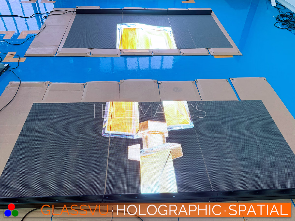 The Art Of Light · GlassVu Spatial · Telematics Canada See-through digital display matrices laid flat during pre-installation testing showcasing bright 3D holographic effects.